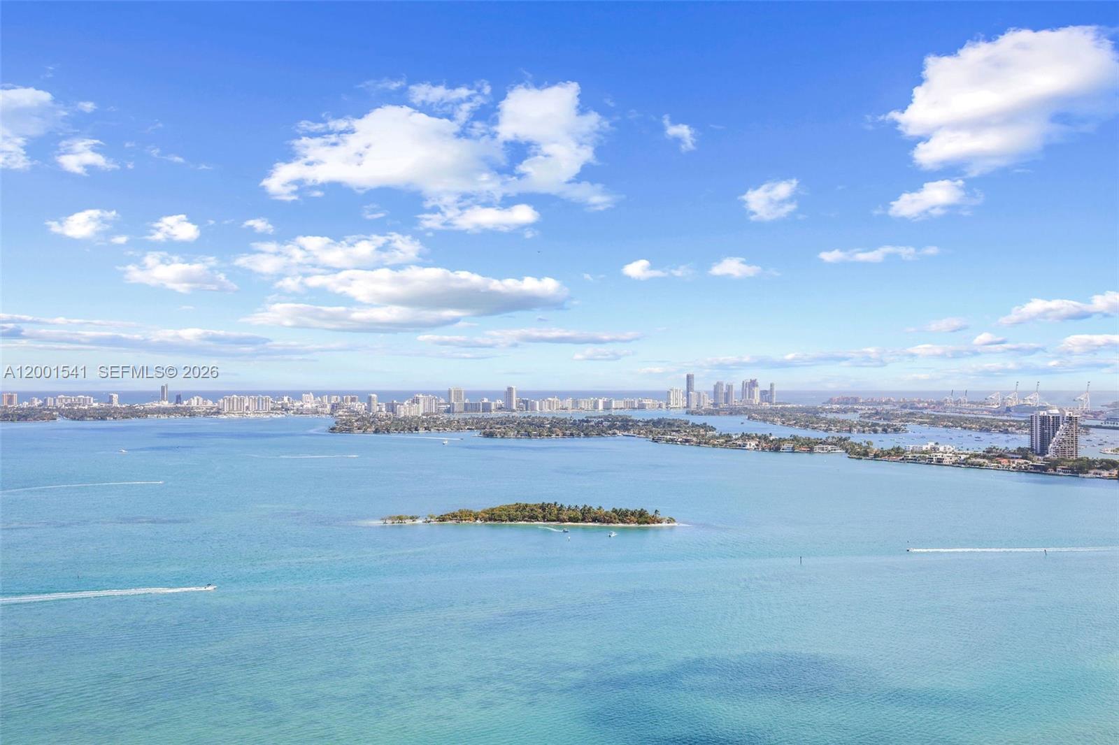 An aerial view shows a body of water with islands and a distant city skyline — 700 NE 26 Ter # 3602, Miami FL 33137, MIAMI, FL
