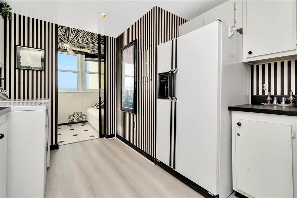 A kitchen with black and white striped wallpaper, white cabinets, and a side-by-side refrigerator — 15462 GULF BOULEVARD UNIT 508, MADEIRA BEACH, FL