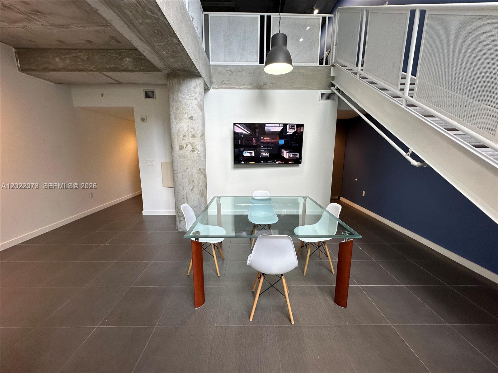 A dining area features a glass table, four chairs, and a wall-mounted television — 3250 NE 1st Ave # 311, Miami FL 33137, MIAMI, FL