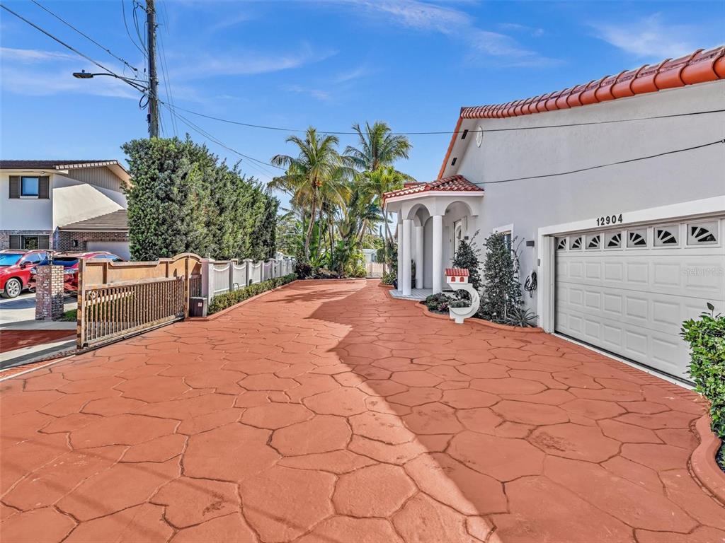 A paved driveway leads to a house with a garage and a covered entryway — 12904 BANYAN ROAD, NORTH MIAMI, FL