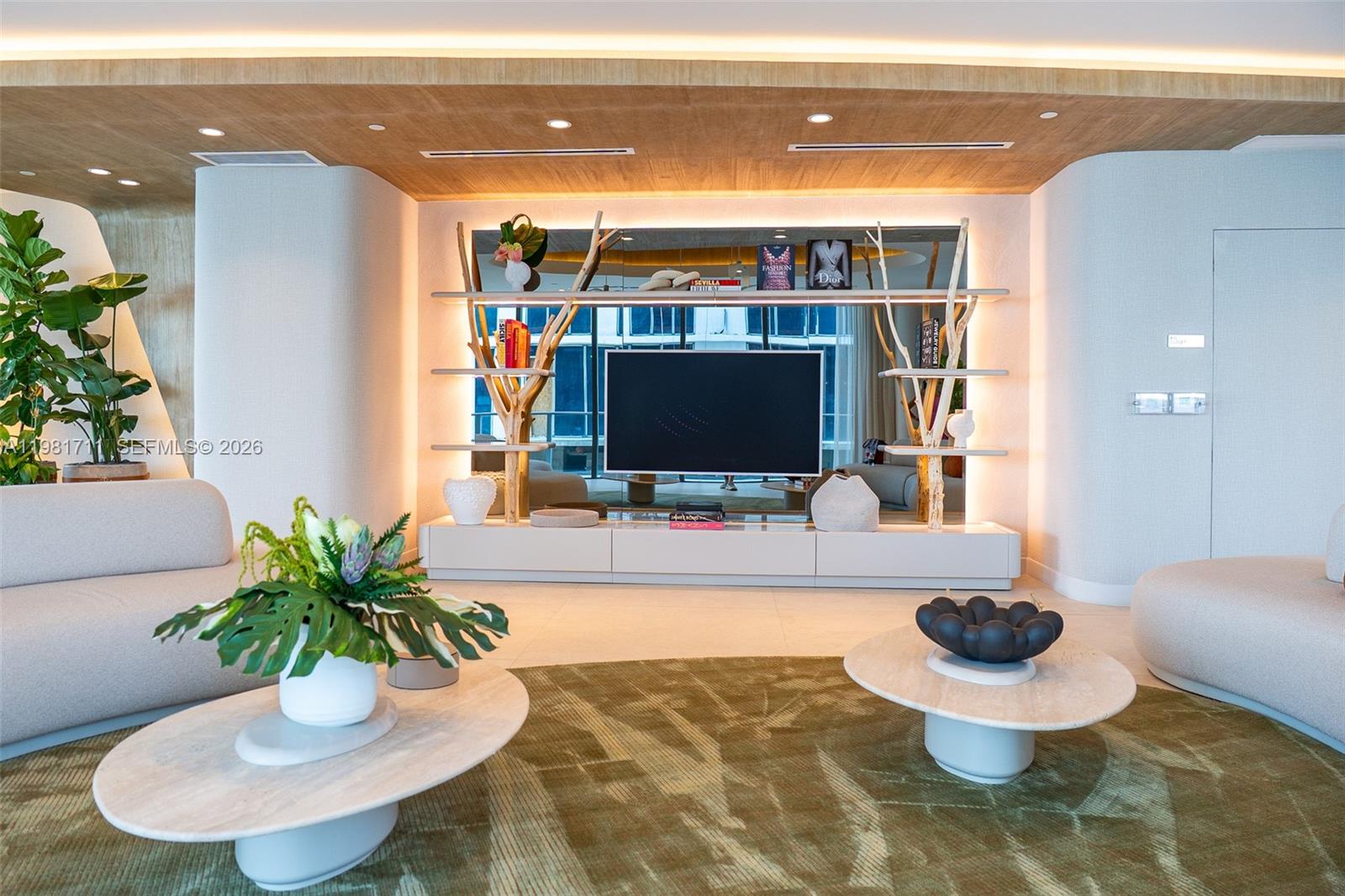 A modern living room features a television mounted on a decorative shelving unit with lighting — 700 NE 24th st # 3603, Miami FL 33137, MIAMI, FL