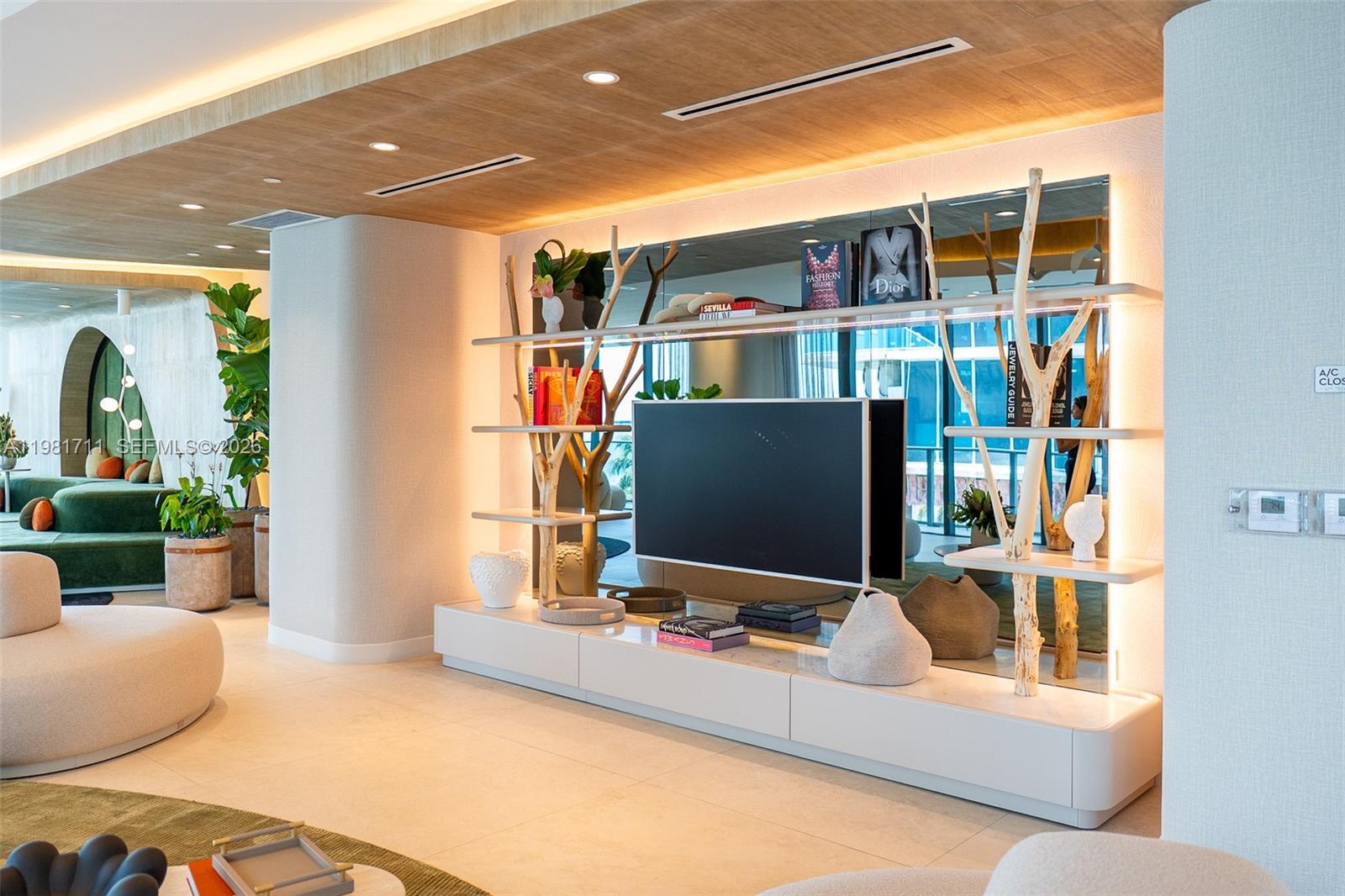 A modern living room features a wall-mounted television integrated into a decorative tree-branch shelving unit — 700 NE 24th st # 3603, Miami FL 33137, MIAMI, FL