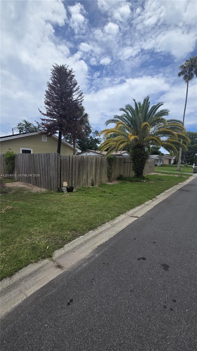 A wooden fence encloses a yard with a tall pine tree and a palm tree — 2845 OAK LEA DR, Daytona FL 32119, DAYTONA, FL
