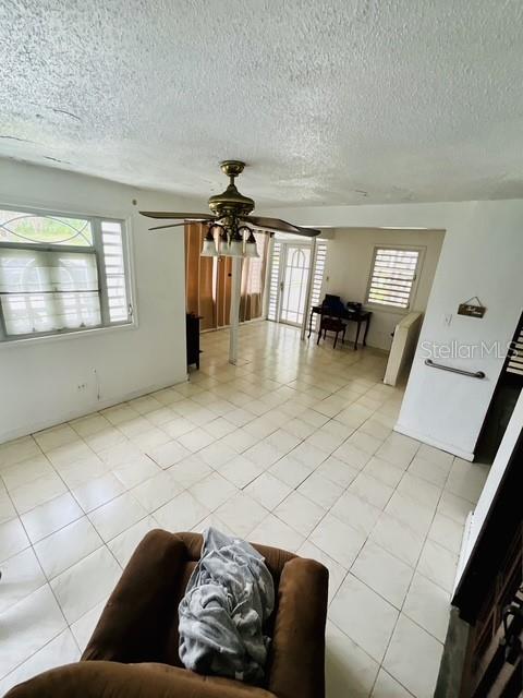 A living room features a ceiling fan, tiled floors, and a view into an adjacent room — C-10 CLL BLANCA, BAYAMON, PR