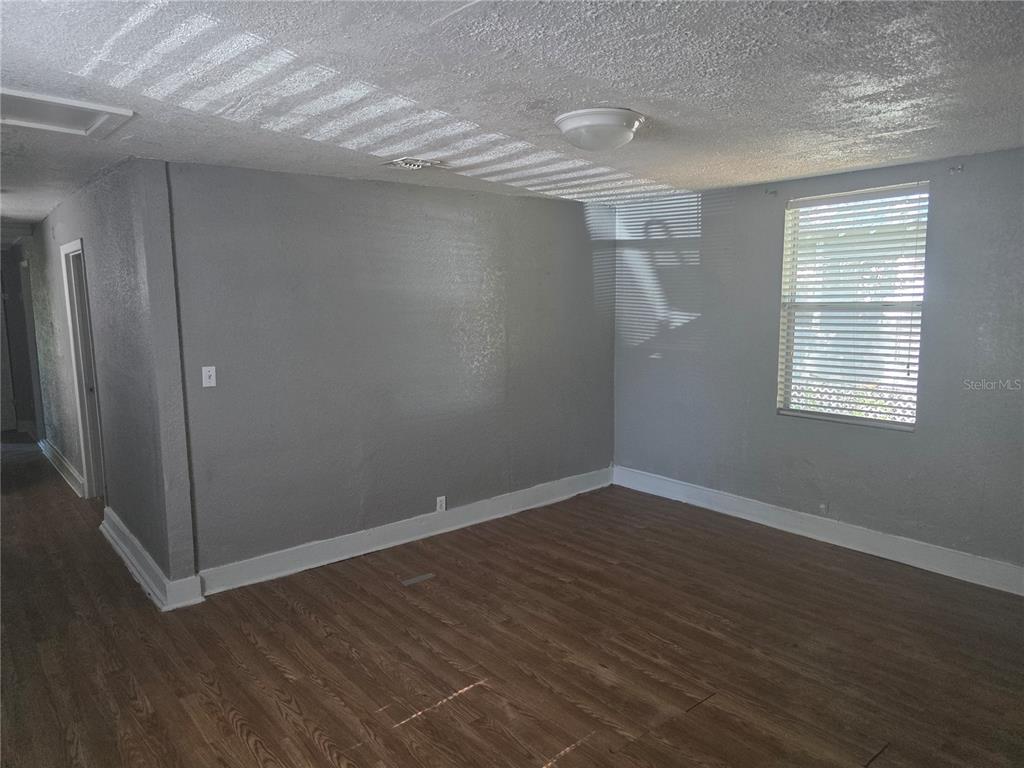 An empty room with gray walls, wood-look flooring, and a single window with blinds — 804 W 29TH STREET, JACKSONVILLE, FL