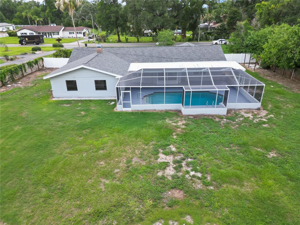 An aerial view of a house with a screened-in pool and a large backyard — 3104 FAIRLEA LANE, VALRICO, FL