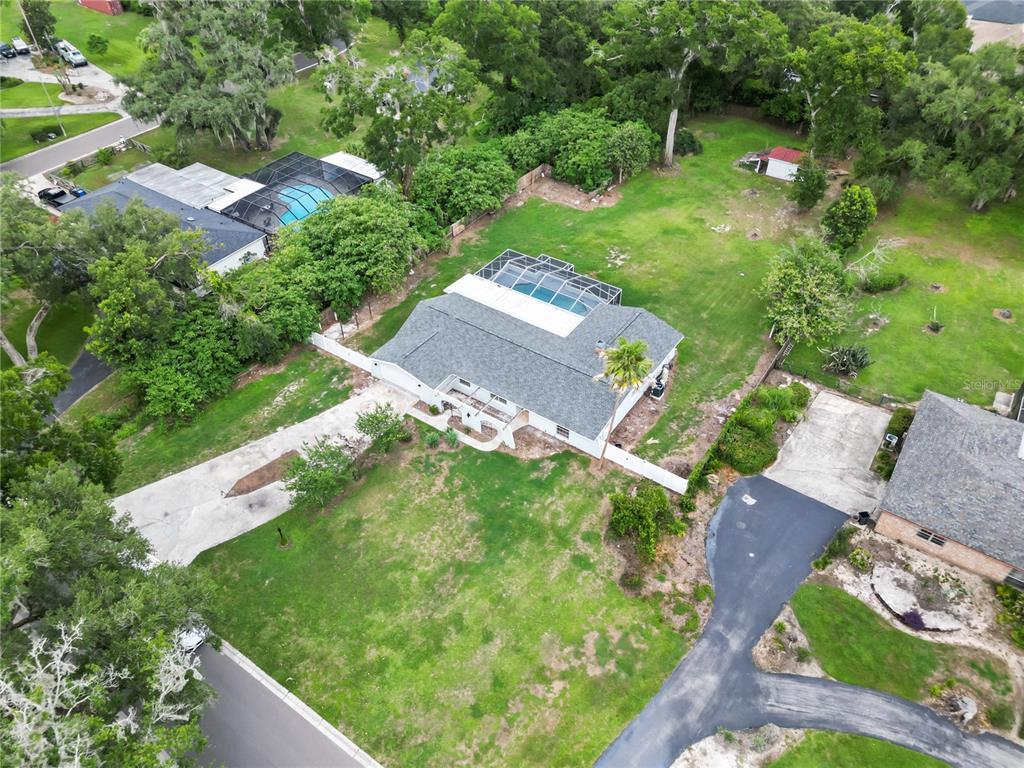 An aerial view shows a house with a pool enclosure, large yard, and paved driveways — 3104 FAIRLEA LANE, VALRICO, FL