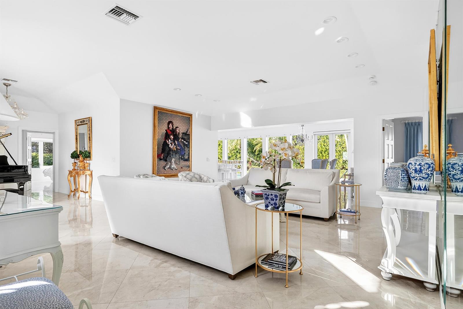 A bright living room features white sofas, marble floors, and a large framed portrait — 107 E Inlet Drive, Palm Beach FL 33480, PALM BEACH, FL