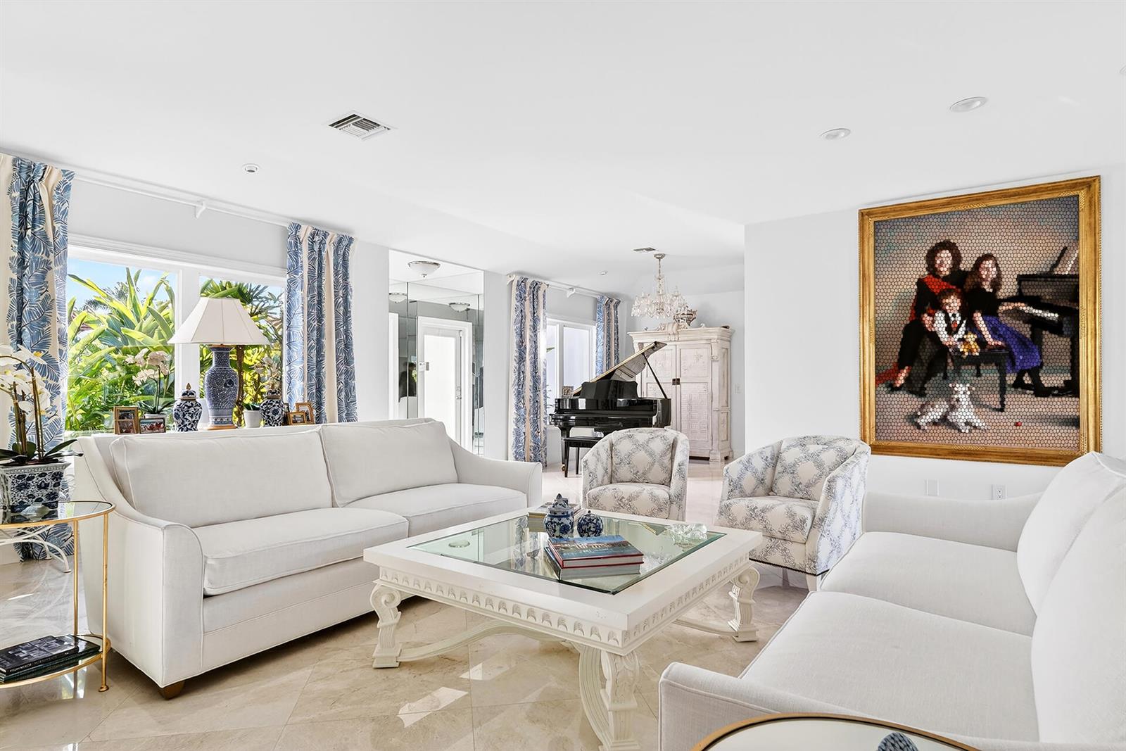 A bright living room features white sofas, a glass-topped coffee table, and a large framed painting — 107 E Inlet Drive, Palm Beach FL 33480, PALM BEACH, FL