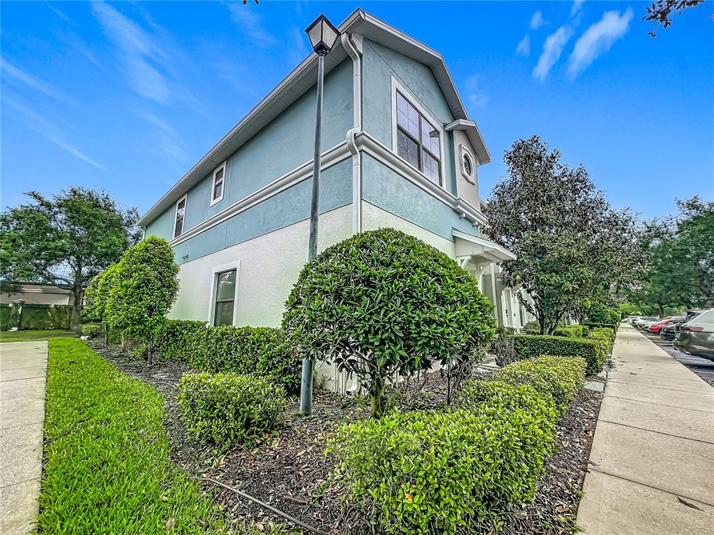 A two-story house exterior with light blue and white siding, landscaping, and a sidewalk — 1360 WINDSOR LAKE CIRCLE, SANFORD, FL