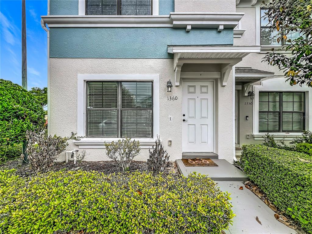 The exterior of a two-story townhouse features a white front door and a large window — 1360 WINDSOR LAKE CIRCLE, SANFORD, FL