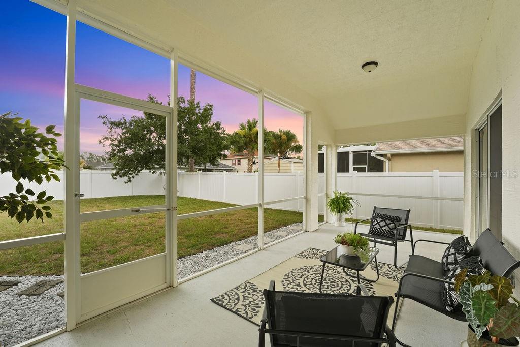 A screened-in patio features a concrete floor, outdoor furniture, and a view of the backyard — 58 RYBERRY DRIVE, PALM COAST, FL