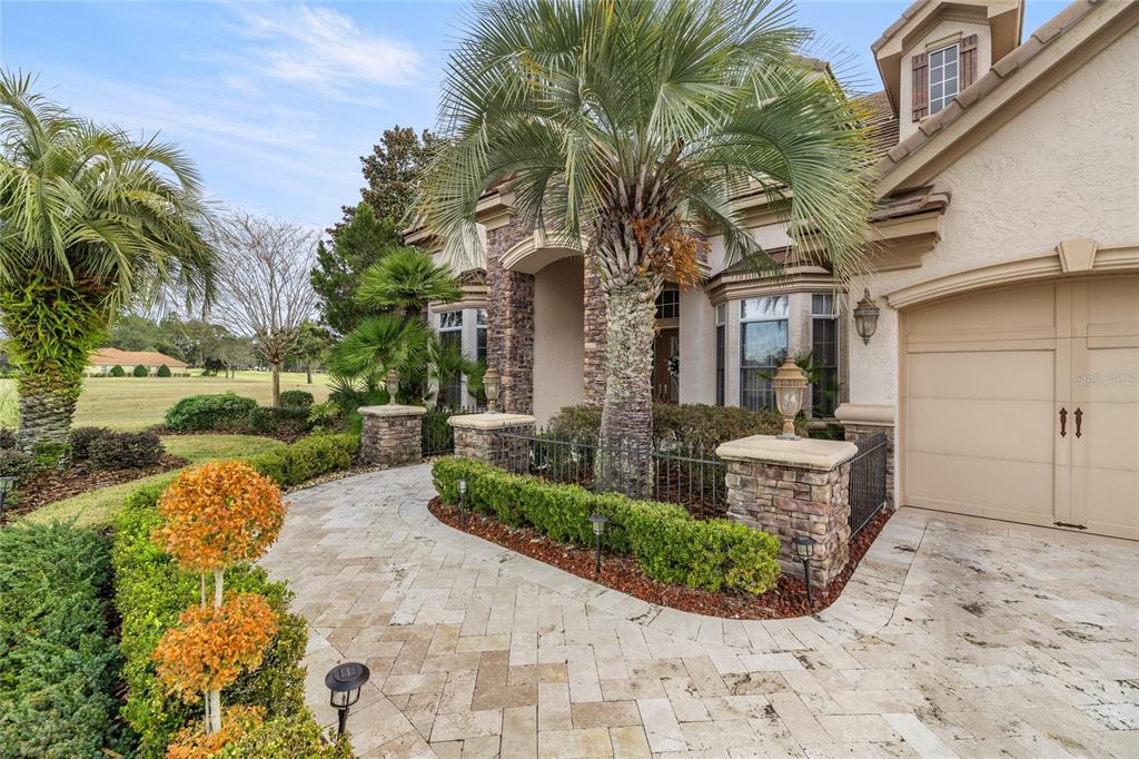 A stone-paved walkway leads to the entrance of a house with a palm tree — 6861 SW 179TH AVENUE ROAD, DUNNELLON, FL
