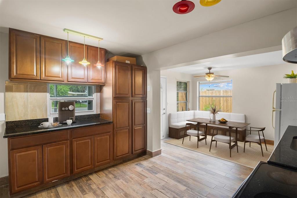 A kitchen with wood cabinets and a dining area featuring a built-in corner bench — 6723 78TH AVENUE N, PINELLAS PARK, FL