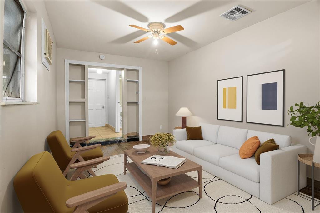 This living room features a white sofa, two mustard armchairs, a coffee table, and shelving — 6723 78TH AVENUE N, PINELLAS PARK, FL