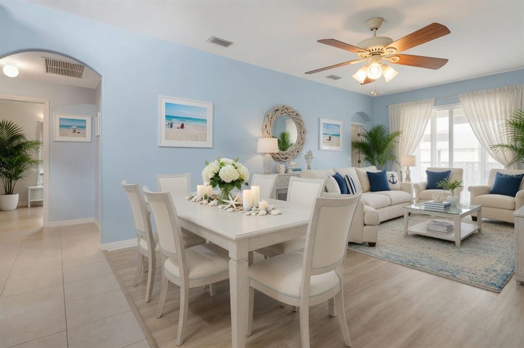 A bright dining and living area features light blue walls, white furniture, and coastal decor — 26903 HONEYMOON AVENUE, LEESBURG, FL