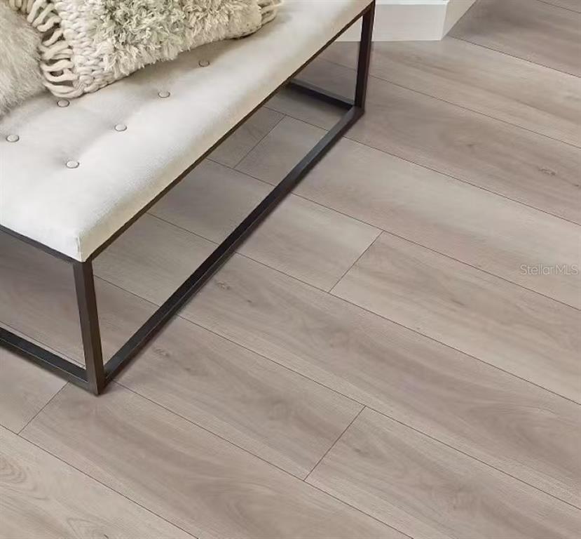 A tufted bench with a textured pillow sits on light-toned wood-look flooring — 1161 TIMBERWOOD DRIVE, WILDWOOD, FL