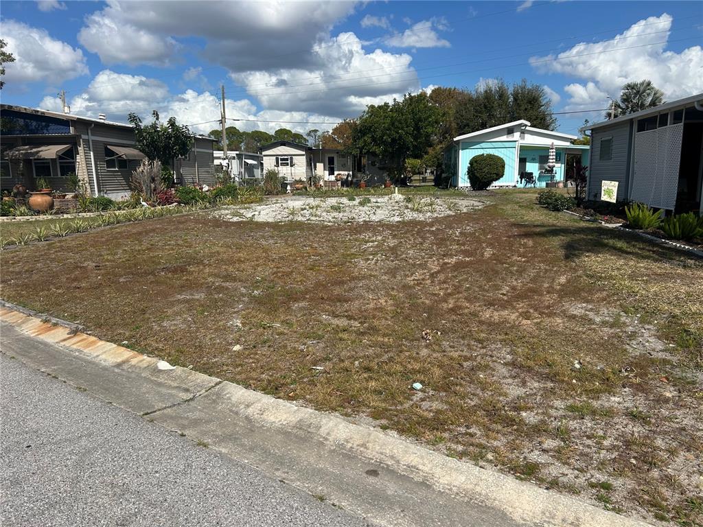 A vacant residential lot with sparse grass and a gravel patch in a mobile home community — 5254 PEBBLE BEACH AVENUE, SARASOTA, FL