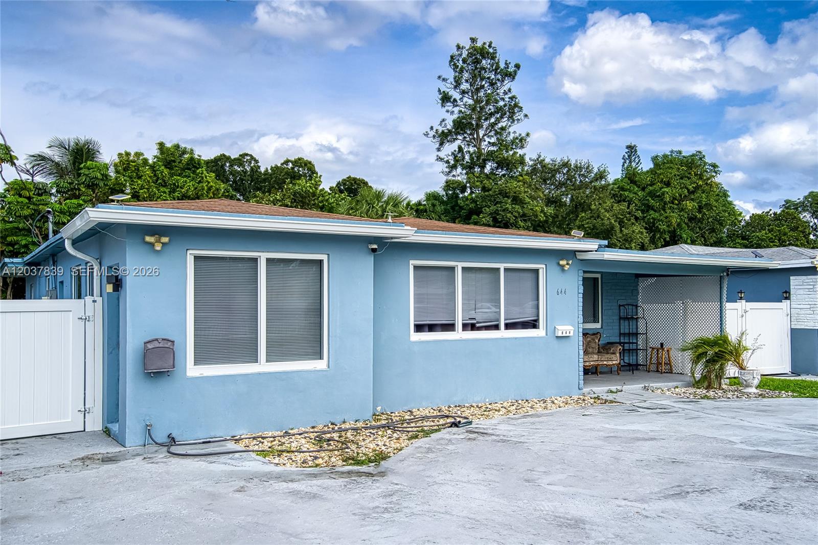 A light blue single-story house features a concrete driveway, white trim, and a covered porch — 644 SW 7th Ct # 0, Hallandale Beach FL 33009, HALLANDALE BEACH, FL