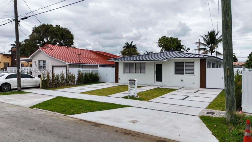 A white single-story house with a metal roof and a concrete driveway sits outdoors — 3536 NW 14th Ter, Miami FL 33125, MIAMI, FL