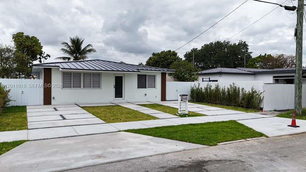 A single-story house with a metal roof, white exterior, and a concrete driveway — 3536 NW 14th Ter, Miami FL 33125, MIAMI, FL