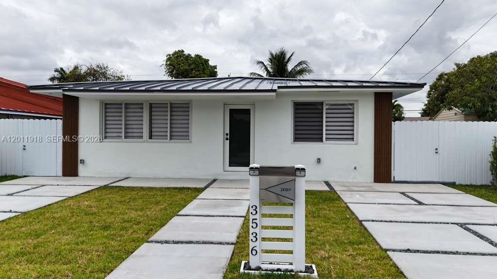 A single-story white house with a metal roof and a modern mailbox in the yard — 3536 NW 14th Ter, Miami FL 33125, MIAMI, FL