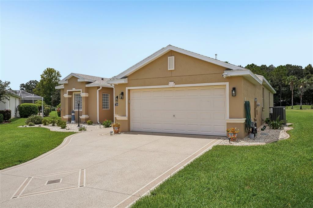 A tan single-story house with a two-car garage and a concrete driveway — 1044 SW 159TH STREET, OCALA, FL