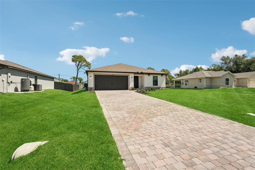 A single-story house with a paved driveway, a two-car garage, and a green lawn — 3378 ESCOBAR LANE, NORTH PORT, FL