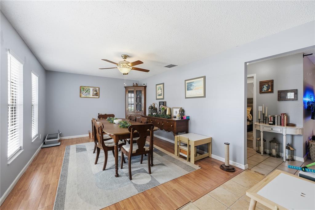 A dining room features a wooden table, chairs, a hutch, and a light-colored area rug — 407 SOUTH AVENUE, EUSTIS, FL