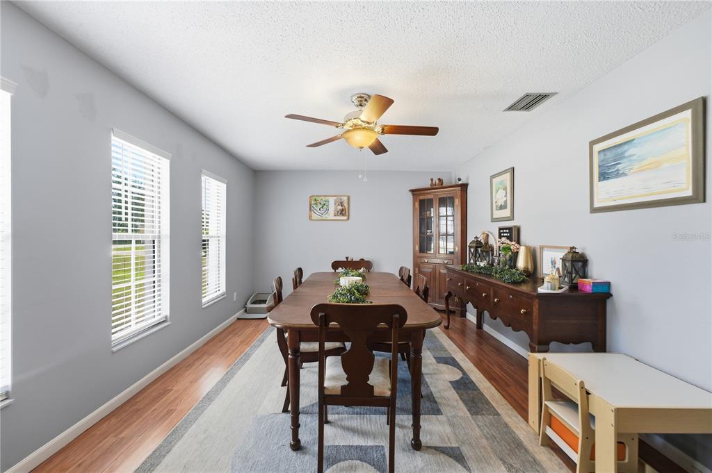 A dining room features a wooden table, chairs, a hutch, and a sideboard on wood flooring — 407 SOUTH AVENUE, EUSTIS, FL
