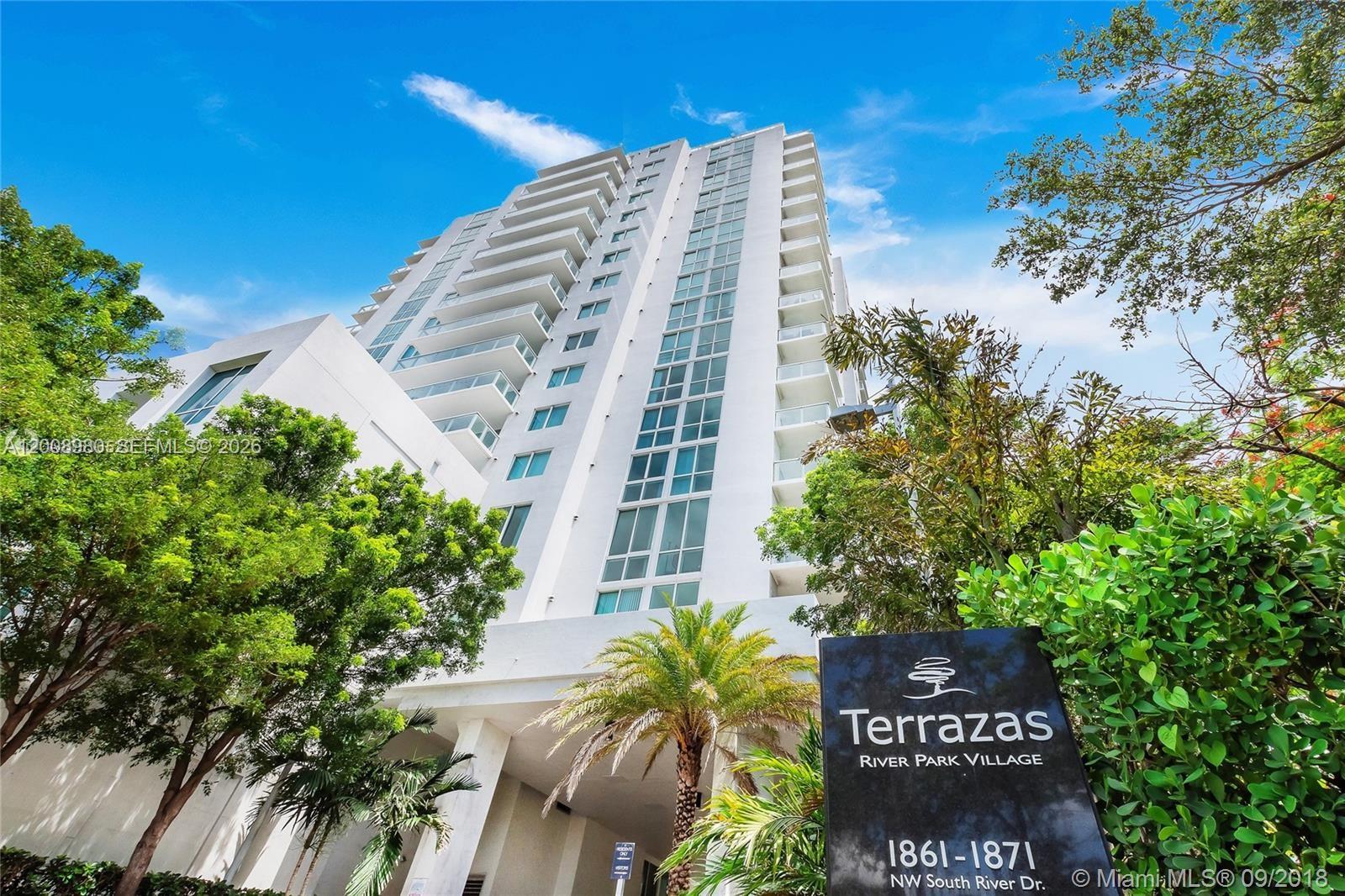 A low-angle view of a white high-rise residential building with a prominent signage sign — 1871 NW S River Dr # 902, Miami FL 33125, MIAMI, FL