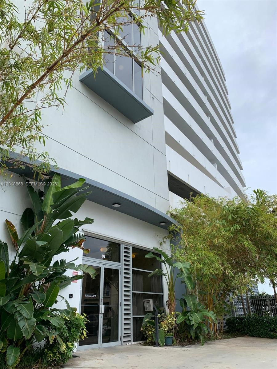 An open-concept living area features wood-look flooring, white walls, and a kitchen with stainless appliances — 36 NW 6th Ave # 1108, Miami FL 33128, MIAMI, FL