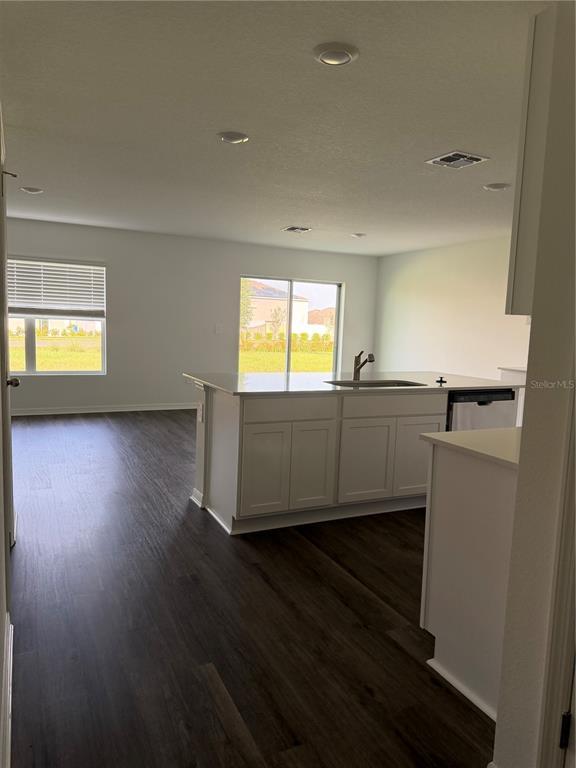 A kitchen with a central island and sink overlooks an open-concept living area — 1723 GRANDIOSE DRIVE, HAINES CITY, FL