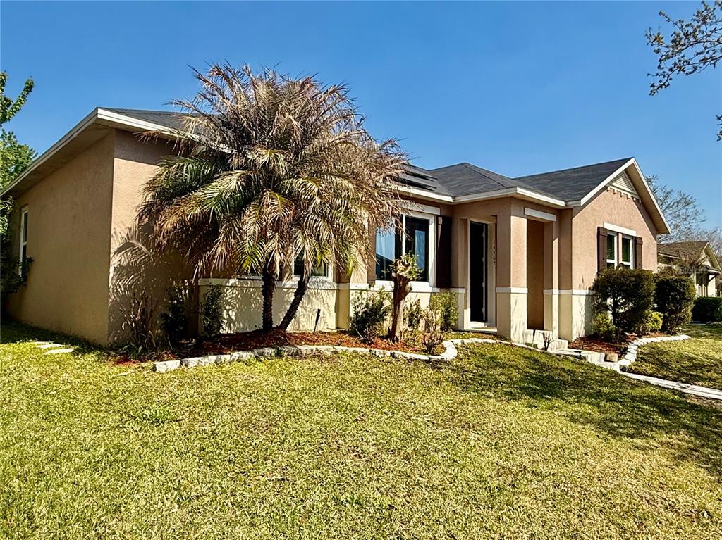 A single-story tan house with a palm tree in the front yard under a blue sky — 14467 GOLDEN RAIN TREE BOULEVARD, ORLANDO, FL