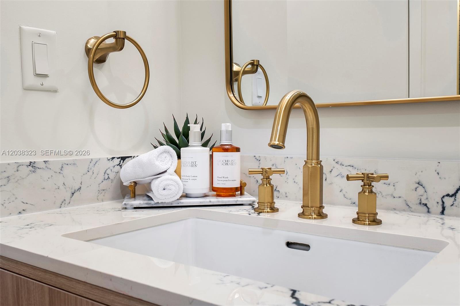 A bathroom vanity features a white marble countertop, gold fixtures, and a rectangular undermount sink — 2700 NW 2nd Ave # 644, Miami FL 33127, MIAMI, FL