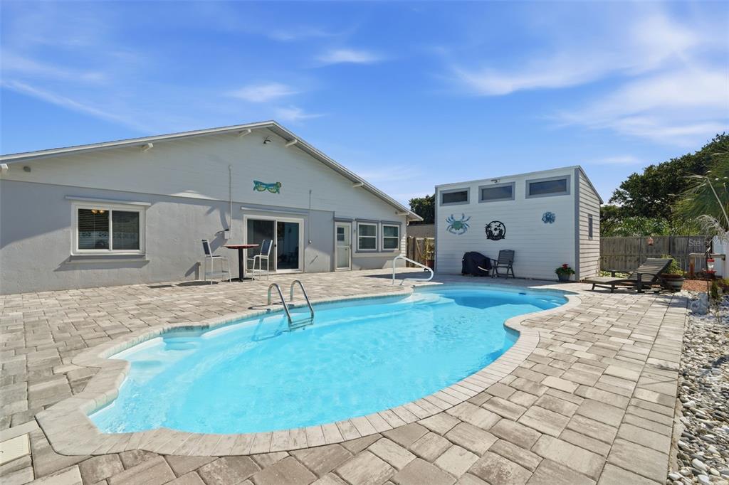 A backyard features a swimming pool with a paver deck and a detached storage shed — 82 JENNIFER CIRCLE, PONCE INLET, FL