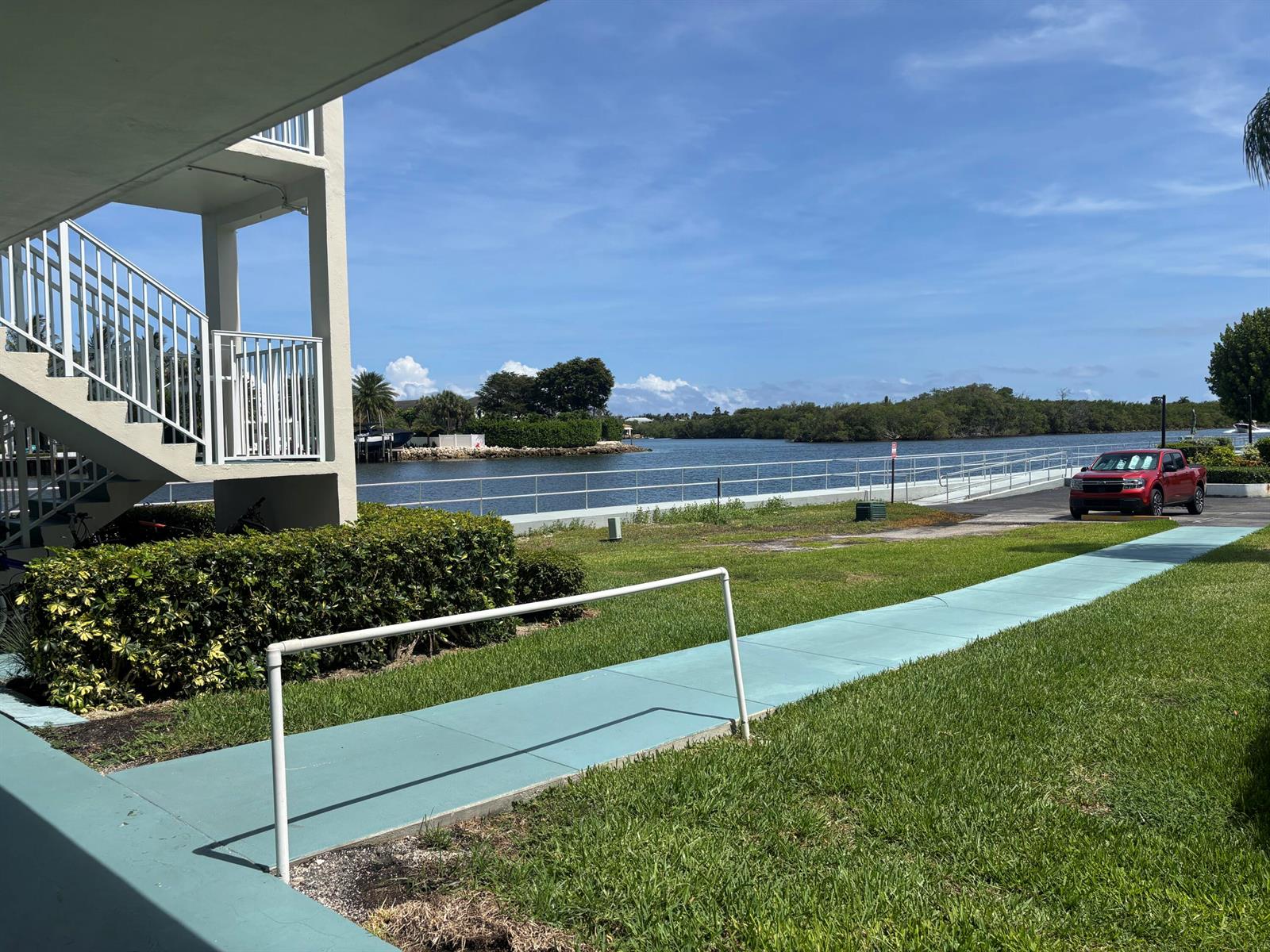 A red truck is parked near a waterfront walkway next to a multi-story building — 170 Horizons E # 110, Boynton Beach FL 33435, BOYNTON BEACH, FL