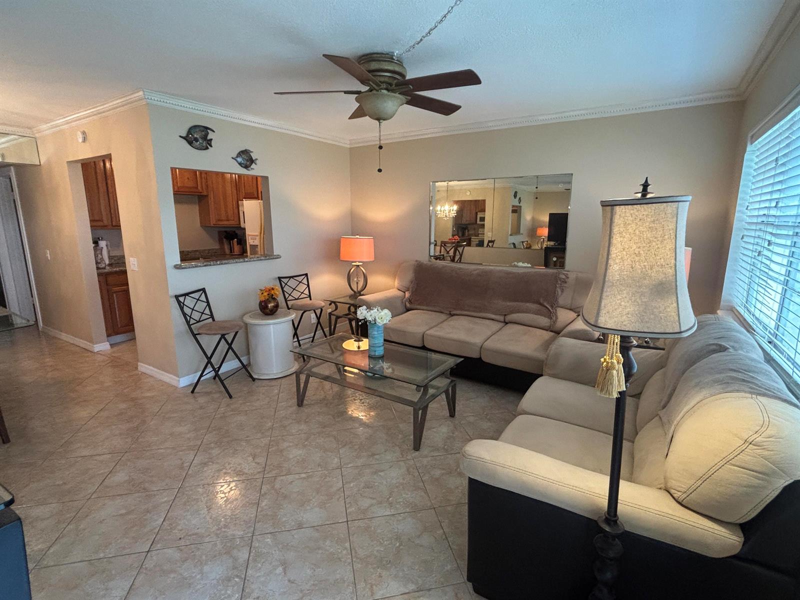 A living room with tile flooring, a ceiling fan, a sofa, and a kitchen pass-through — 170 Horizons E # 110, Boynton Beach FL 33435, BOYNTON BEACH, FL
