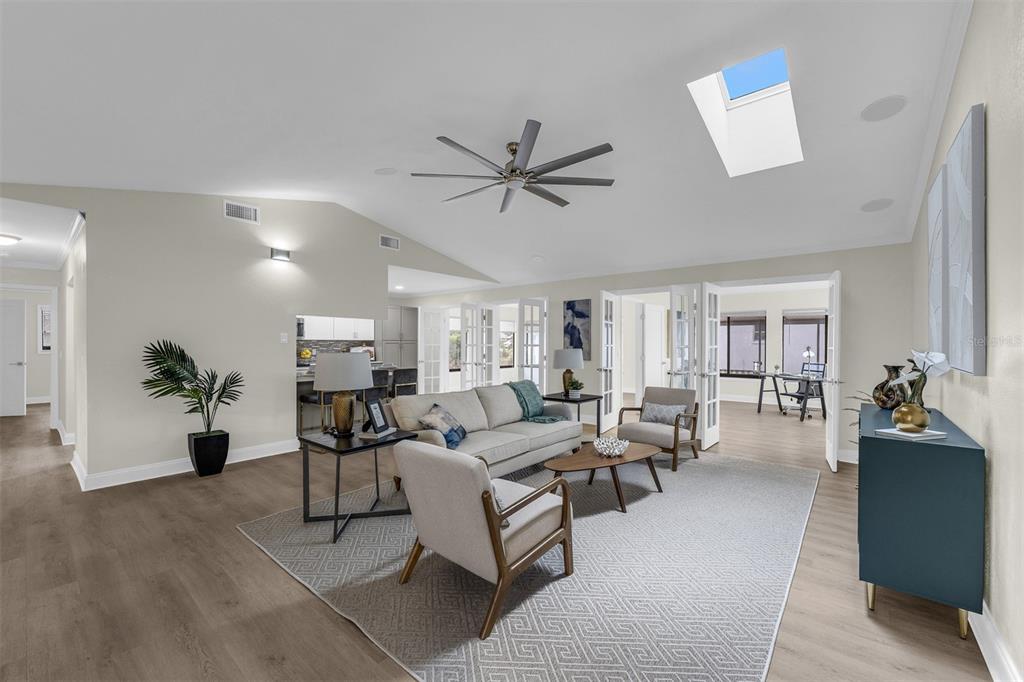 A living room features a vaulted ceiling with a skylight, ceiling fan, and hardwood flooring — 716 GREEN RD, NEW SMYRNA BEACH, FL