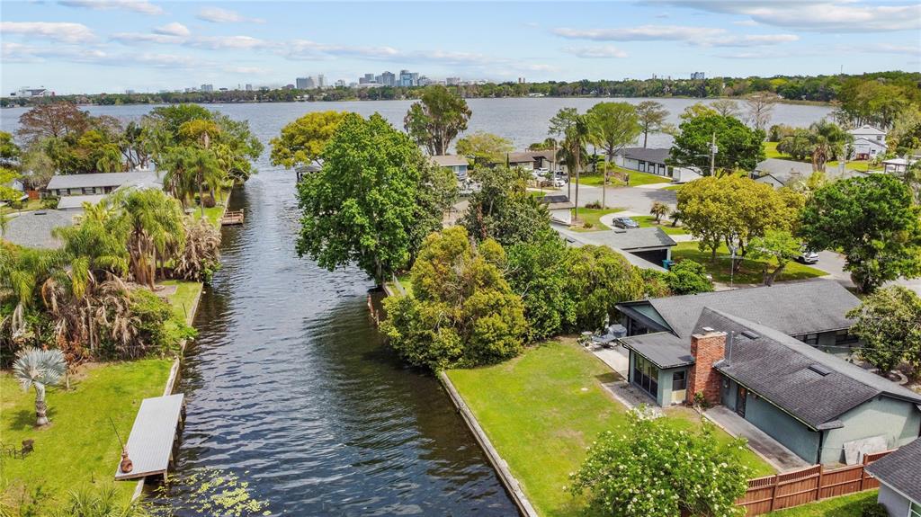 An aerial view shows a canal leading to a lake with houses and trees nearby — 2601 WINDWARD COURT, ORLANDO, FL