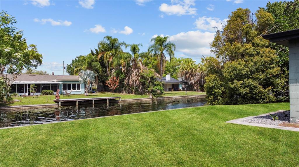 An aerial view shows a brick house with a dark roof, driveway, and backyard canal — 2601 WINDWARD COURT, ORLANDO, FL