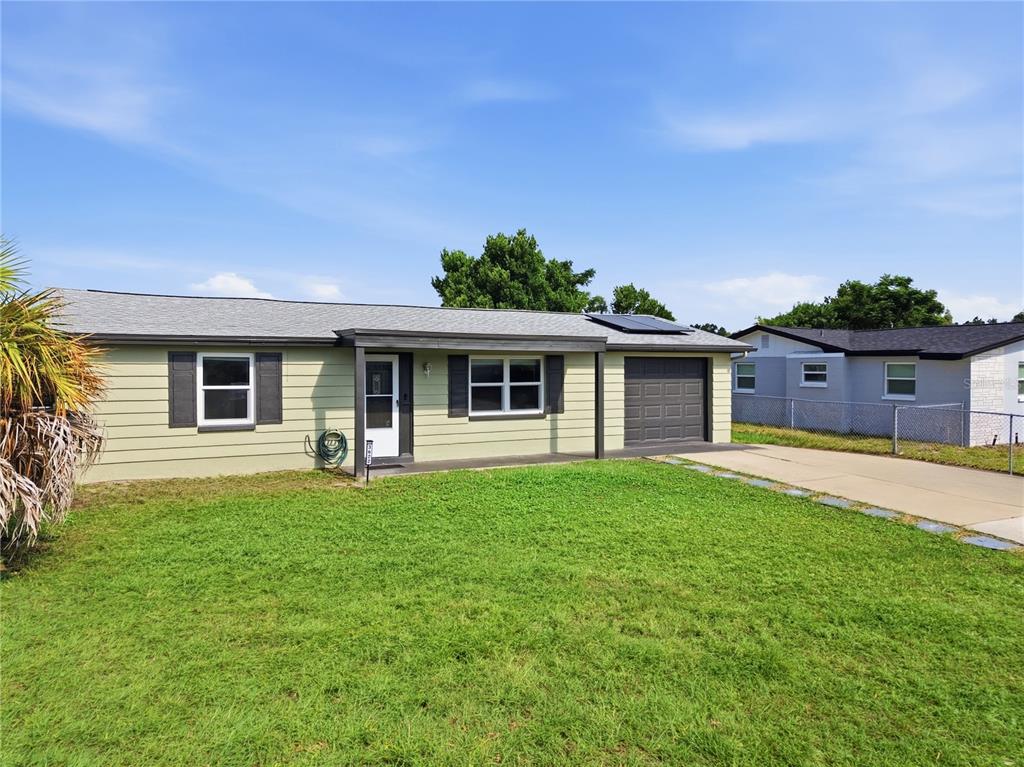 A single-story house with light green siding, a gray roof, and an attached garage — 3622 WINDER DRIVE, HOLIDAY, FL