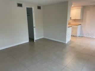 An interior view showing a living area with tile flooring leading to a kitchen — 208 MAGNOLIA AVENUE UNIT B, ANNA MARIA, FL
