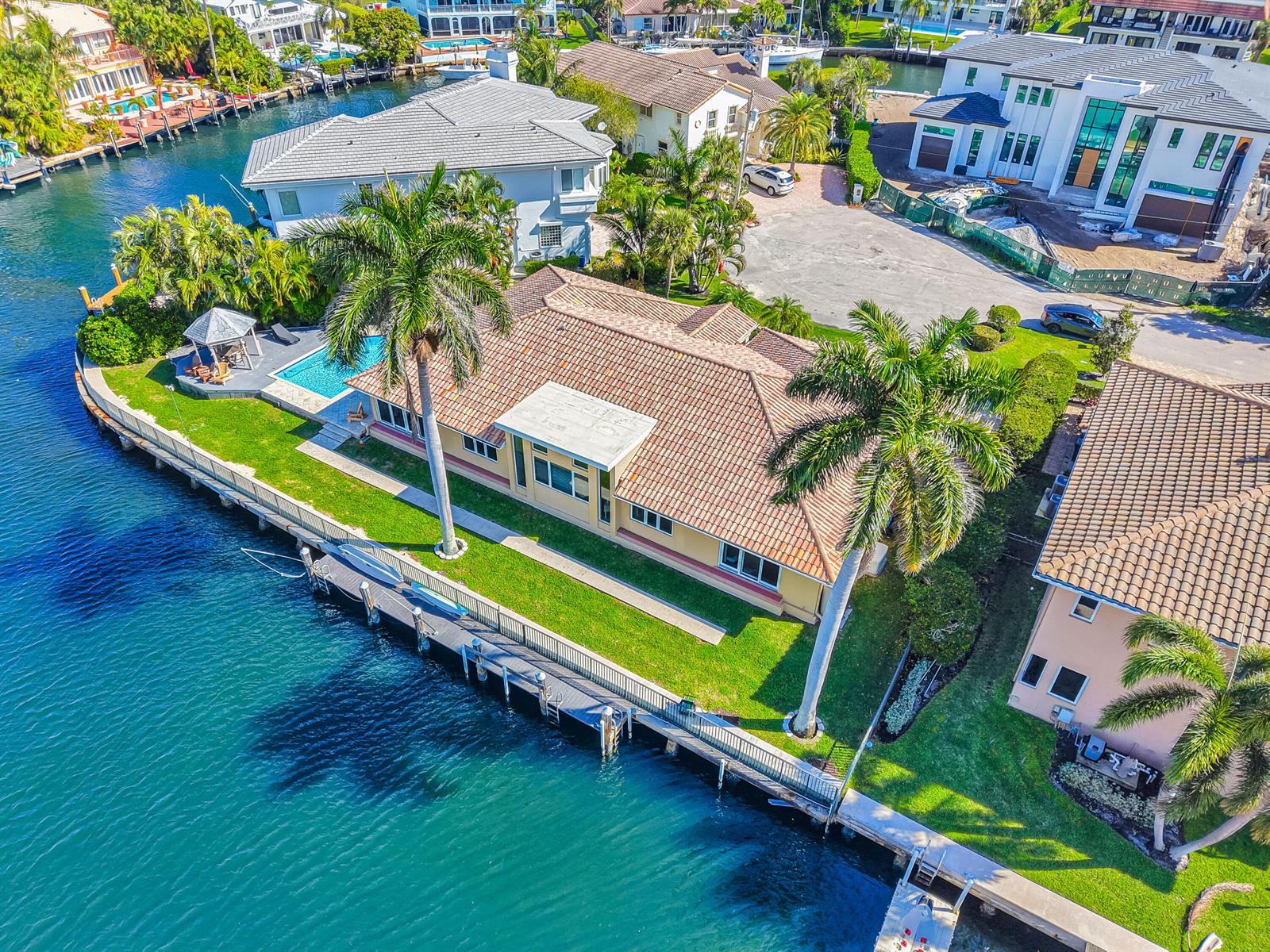 An aerial view of a waterfront home featuring a tiled roof, pool, and boat dock — 4204 Tranquility Drive, Highland Beach FL 33487, HIGHLAND BEACH, FL
