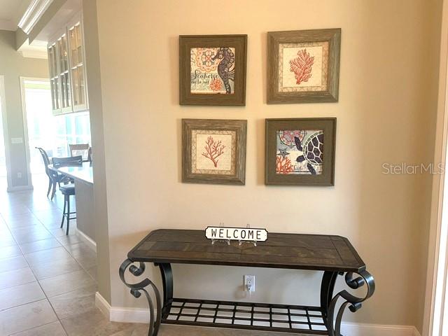 A console table sits beneath four framed nautical-themed pictures on a beige wall — 11818 FIORE LANE, SARASOTA, FL
