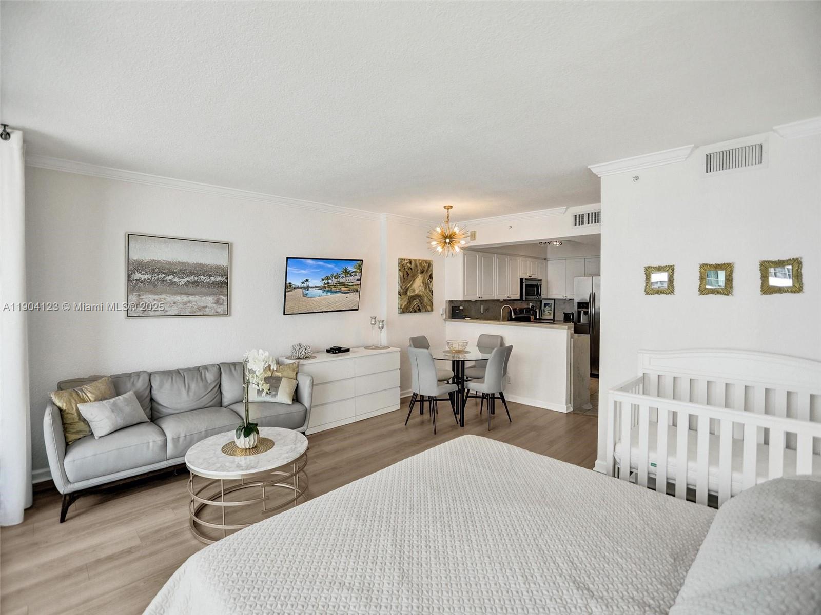 A studio apartment features a living area, dining set, kitchen, and a baby crib — 2501 S Ocean Dr # 505, Hollywood FL 33019, HOLLYWOOD, FL