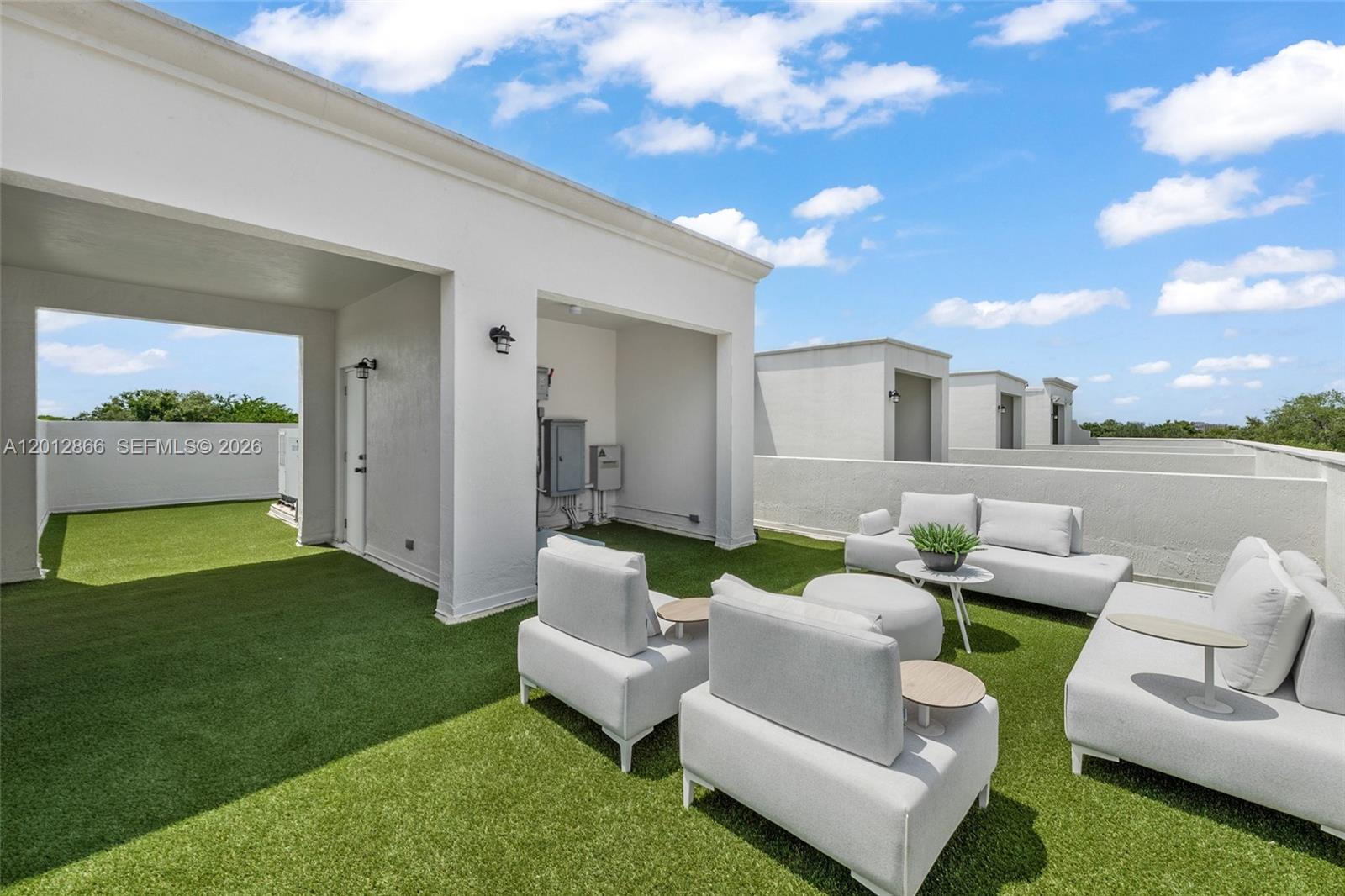 A rooftop terrace features artificial turf, white outdoor furniture, and a covered patio area — 345 Madeira Ave # 345, Coral Gables FL 33134, CORAL GABLES, FL