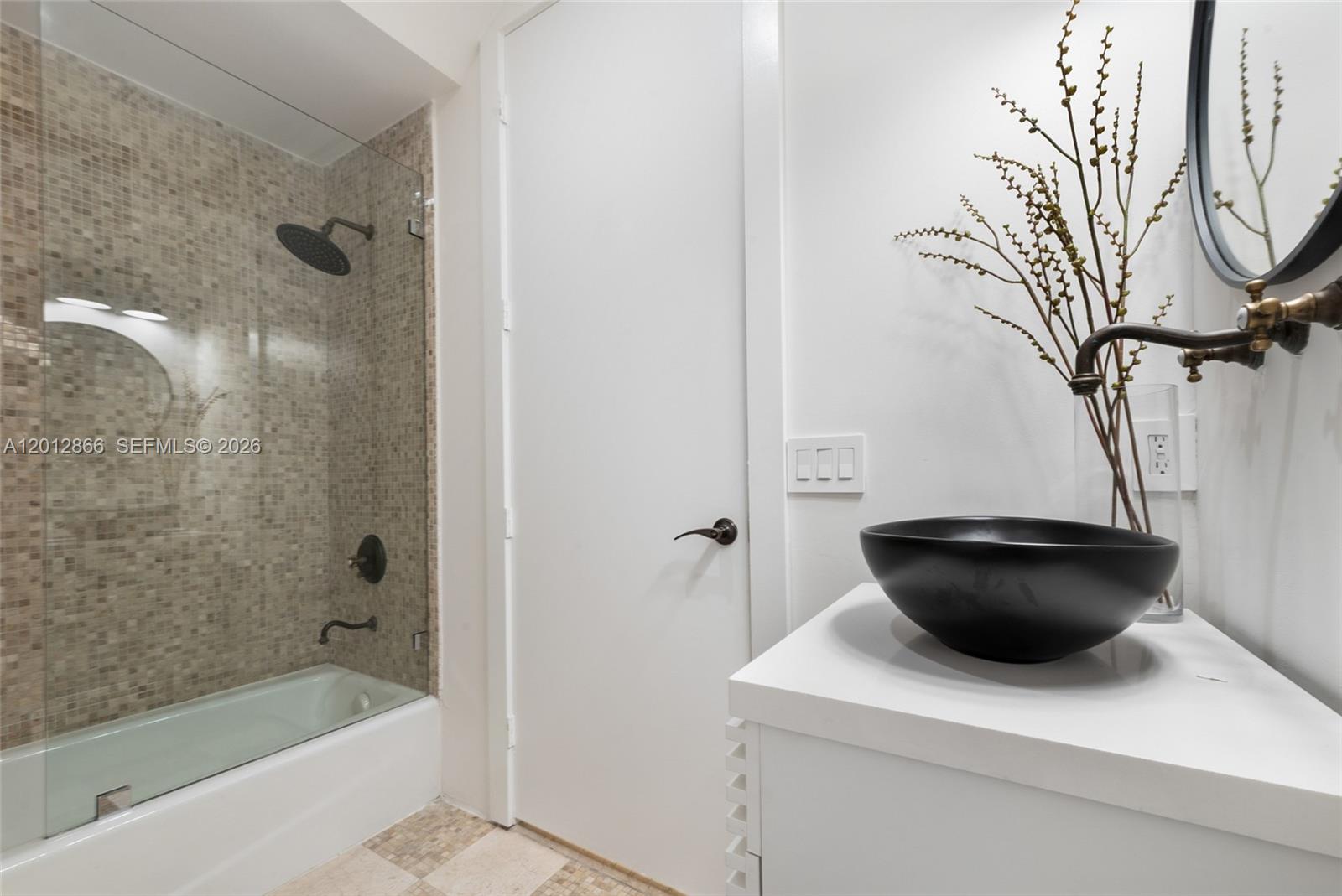 A bathroom features a glass-enclosed tub, a black vessel sink, and a white vanity — 345 Madeira Ave # 345, Coral Gables FL 33134, CORAL GABLES, FL