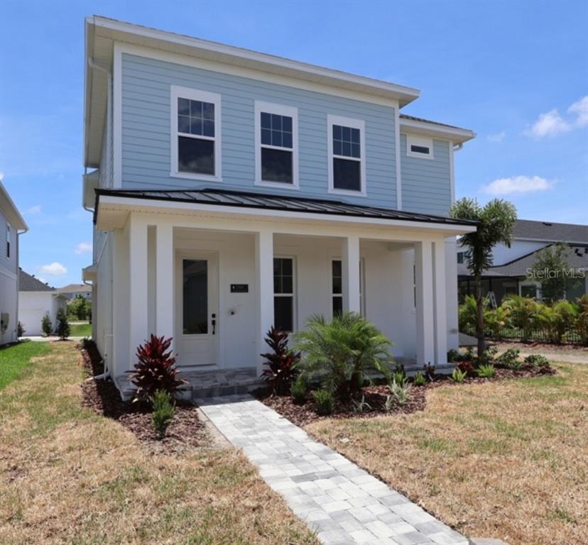 A two-story house with light blue siding, a white porch, and a stone walkway — 7300 DONNYBROOK LANE, SARASOTA, FL