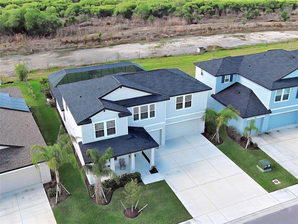 An aerial view shows a two-story house with a dark roof and a screened pool — 17154 MONTE ISOLA WAY, NORTH FORT MYERS, FL